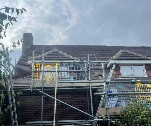 This is a photo of a roof with two dormers that is having some damaged tiles replaced. Works carried out by FDC Roofing Finedon